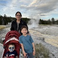 AwomanandtwoyoungboysposeinfrontofthebubblingmudpotsinYellowstoneNationalPark