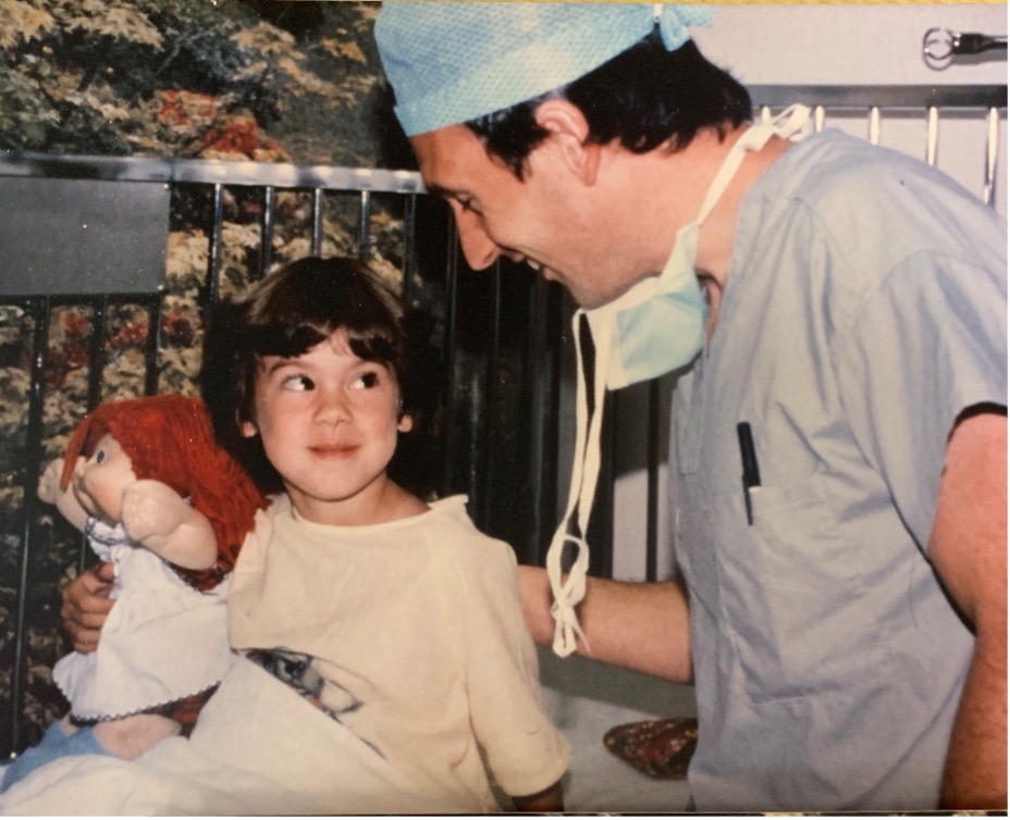 Sarah Horn as a child holds a Cabbage Patch Doll as she meets with an anesthesiologist.