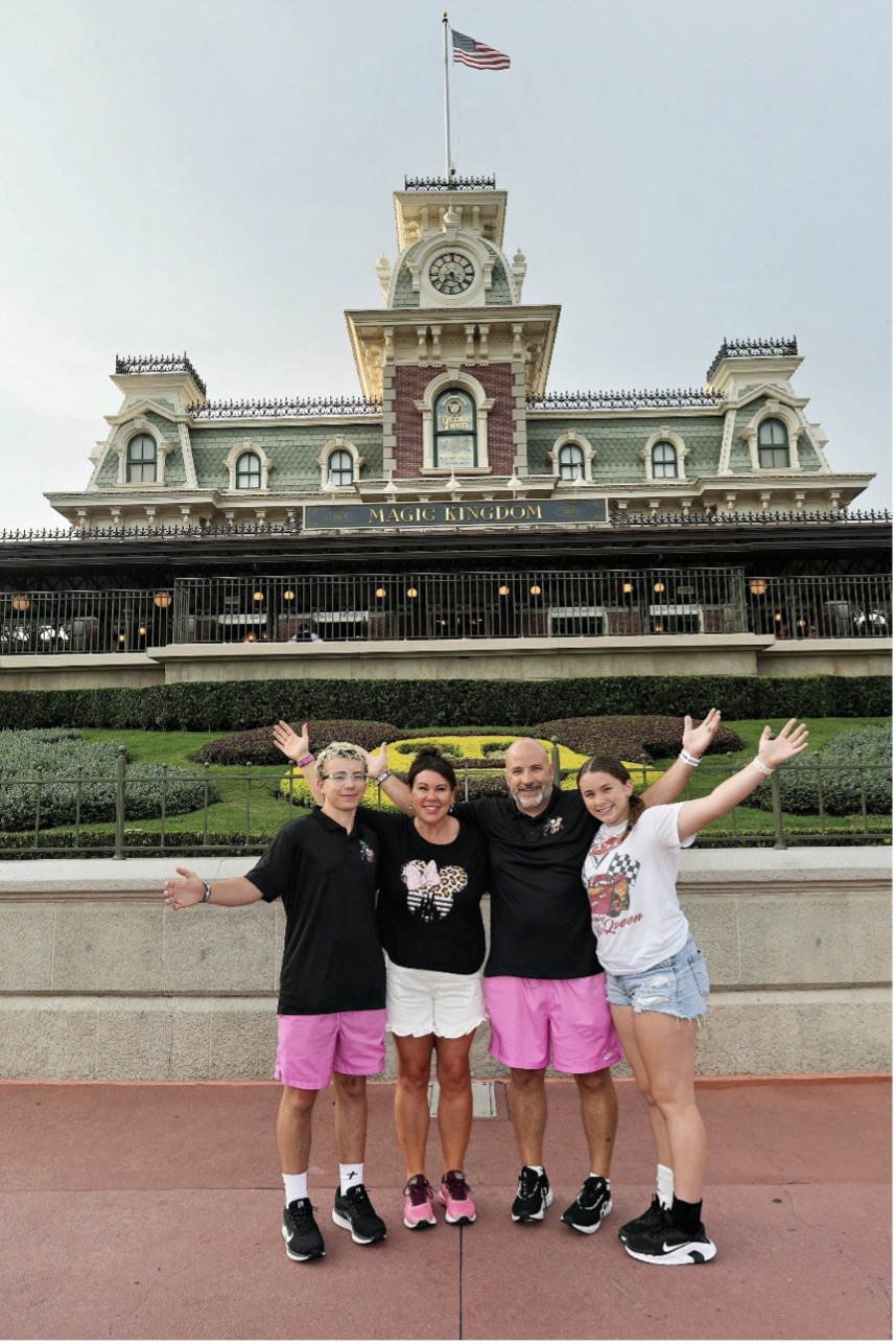 Sarah Horn stands with her husband and two kids in front of Magic Kingdom.