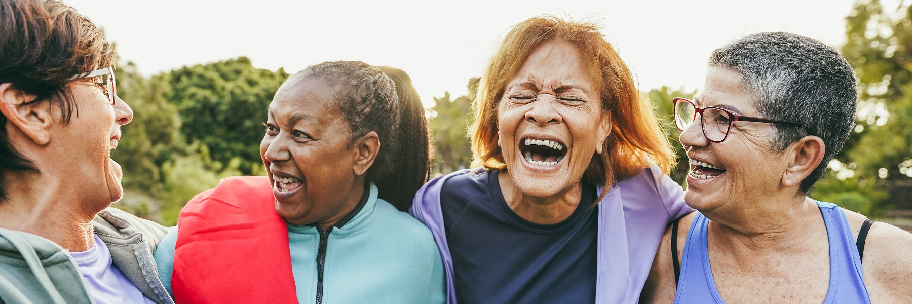 Multiracialseniorwomenlaughingtogetherafteroutdooryogaclass
