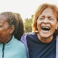 Multiracialseniorwomenlaughingtogetherafteroutdooryogaclass