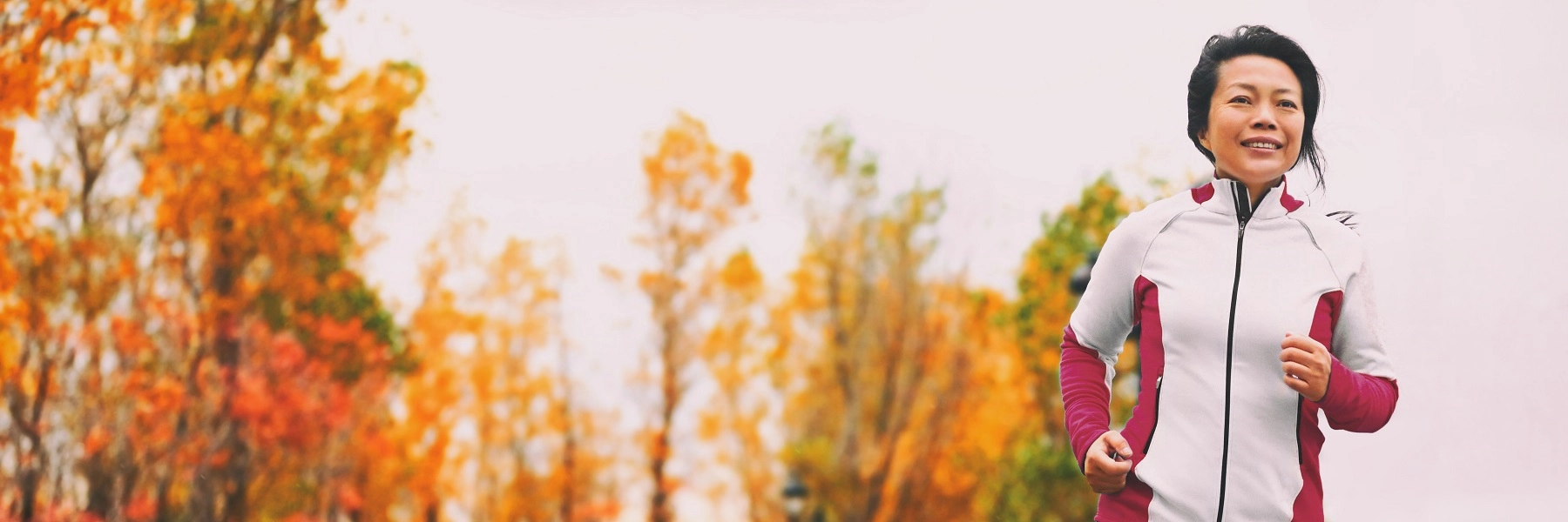 MiddleagedwomanofAsianancestryjoggingoutdoors