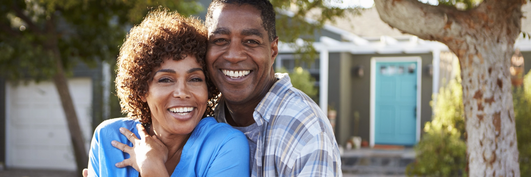 Manandwomanstandingtogetherandsmiling