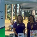 TwoSalemHealthCHECstaffersstandingbehindinformationtableatacommunityevent