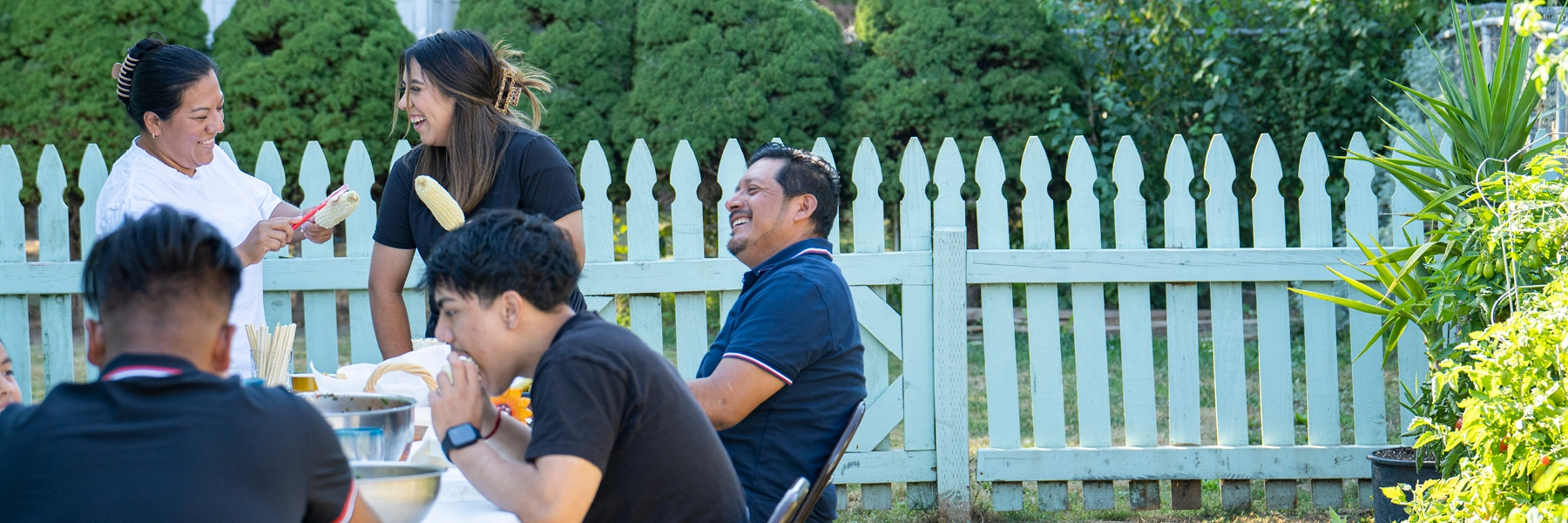 ALatinxfamilyenjoysapicnicdinnerintheirbackyard