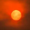Thesunshowsorangethroughahazeofredsmokeclouds