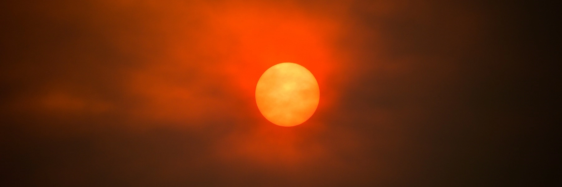 Thesunshowsorangethroughahazeofredsmokeclouds