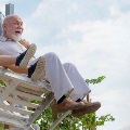 Oldgrandfatherandyoungchildgrandsonswingingingardenoutdoors