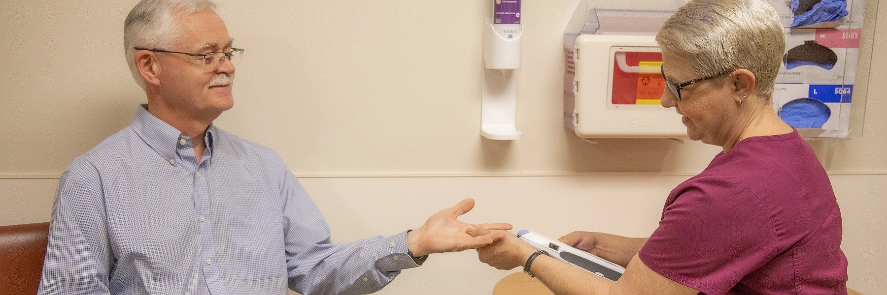 Anurseusesahandheldtestingdeviceonapatientshand