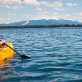 Womanwithponytailkayakinginamountainlake