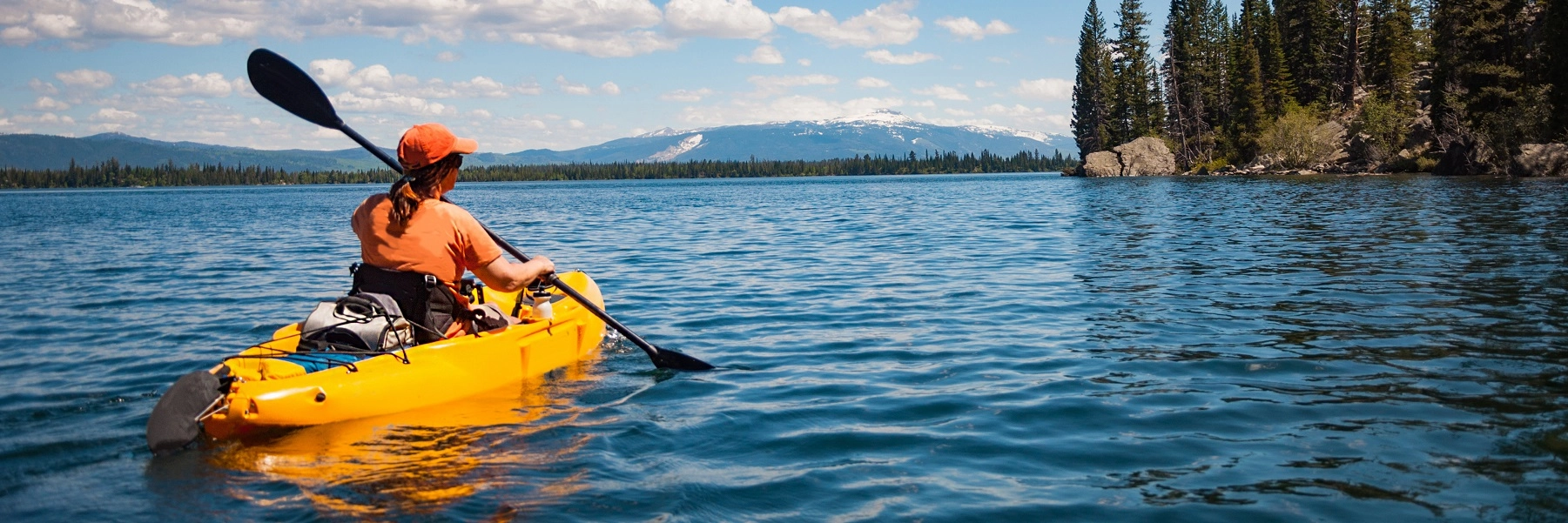 Womanwithponytailkayakinginamountainlake
