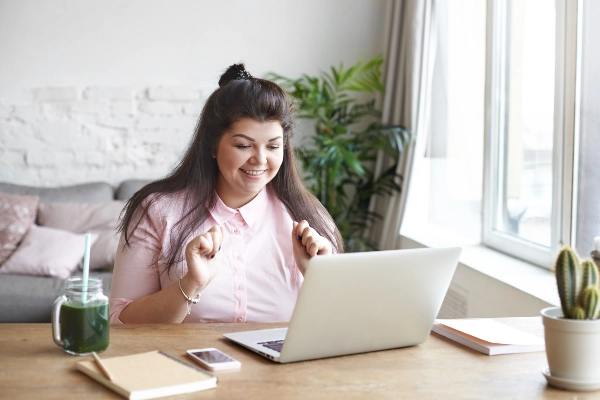 Excited woman using a laptop