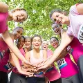 Groupofsmilingwomenwithhandstogetheratcancerevent