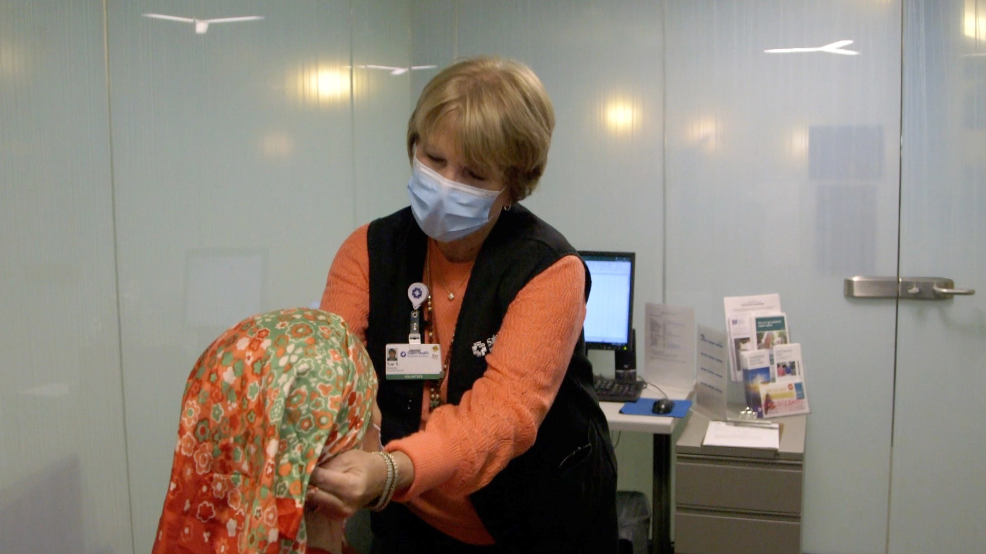 Sue placing a headscarf on a cancer patient