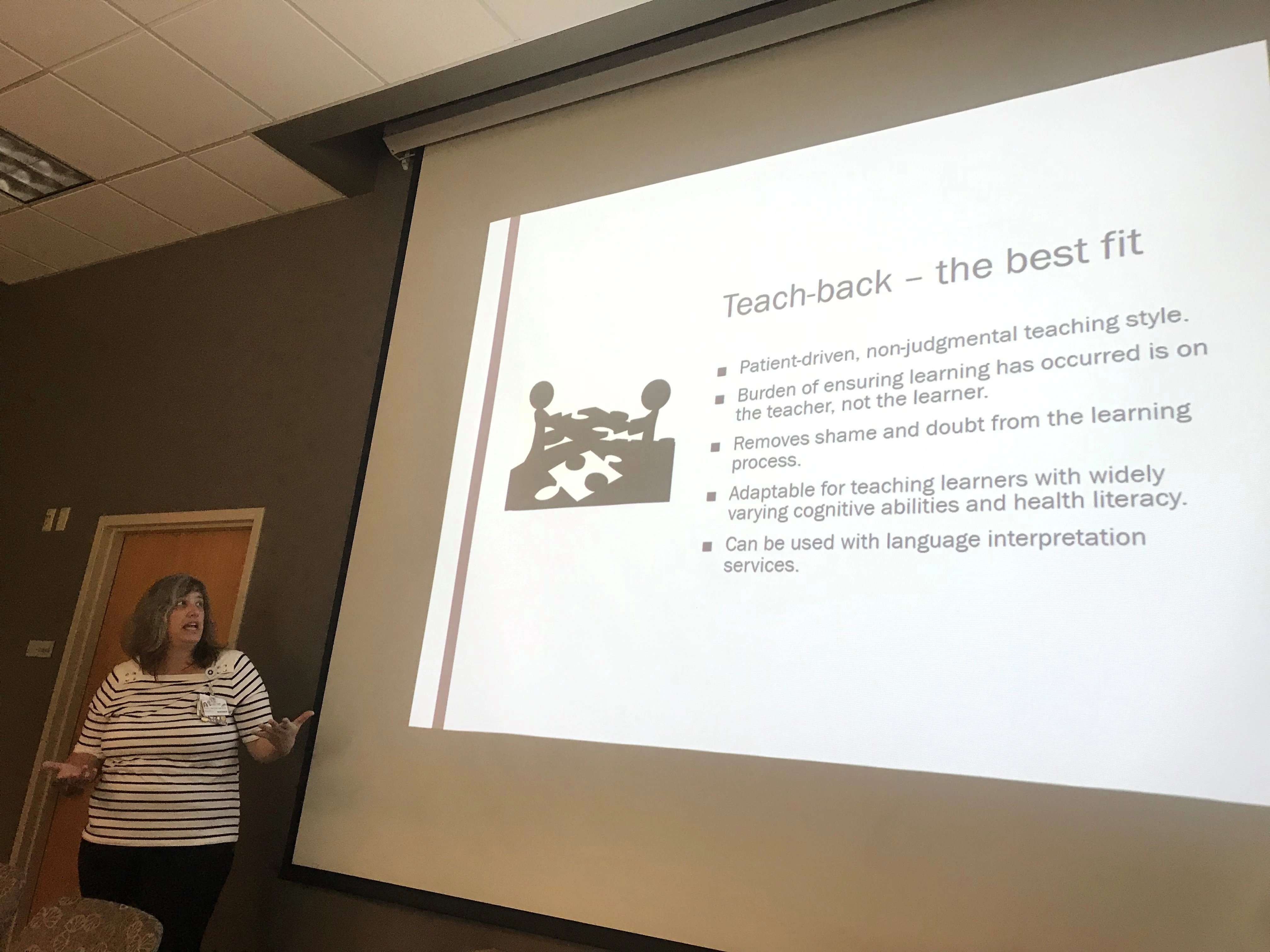 Awomanbyascreendisplayingateachbackslide