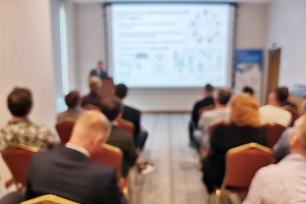 Blurred background image of audience in a business conference or seminar.