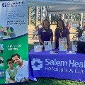 TwoSalemHealthCHECstaffersstandingbehindaninformationtableatarecentcommunityevent
