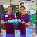 TwoSalemHealthCHECstaffersservehealthsnacksatcommunityevent