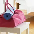 Adufflebagandyogamatpackedupsittingontopofachair