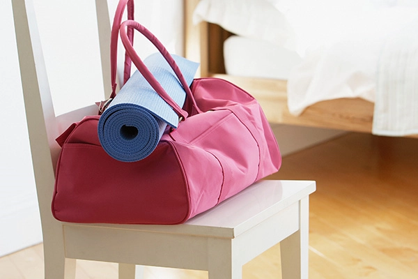 Adufflebagandyogamatpackedupsittingontopofachair