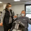 Cardiacrehabtherapistassitingpatientonanexercisebike