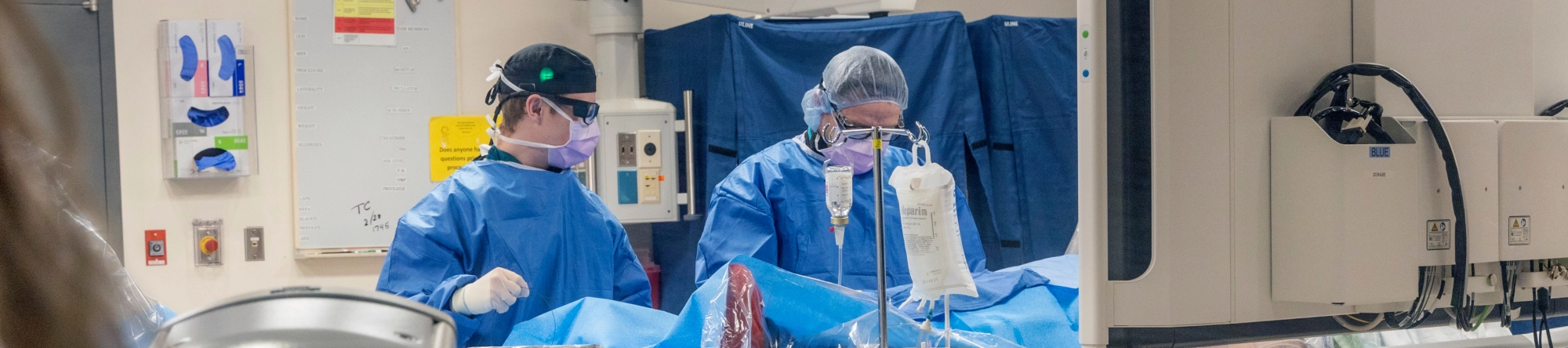 Twocathlabdoctorsdoingaprocedureonapatient