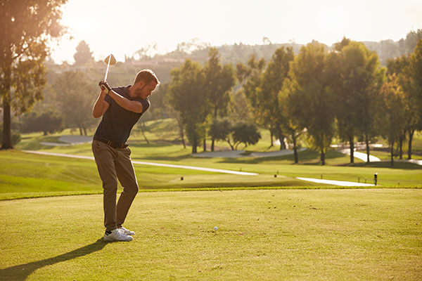 Golfer on the course at sunset