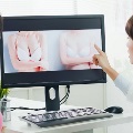Plasticsurgeonandpatientlookingatbreastsurgeryoptionsoncomputer