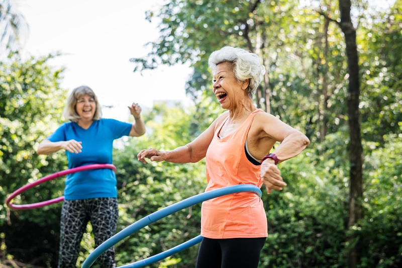 Joyful older women playing with hula-hoops