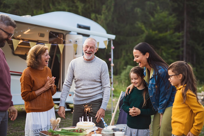 Multi-generation family celebrating birthday outdoors at campground