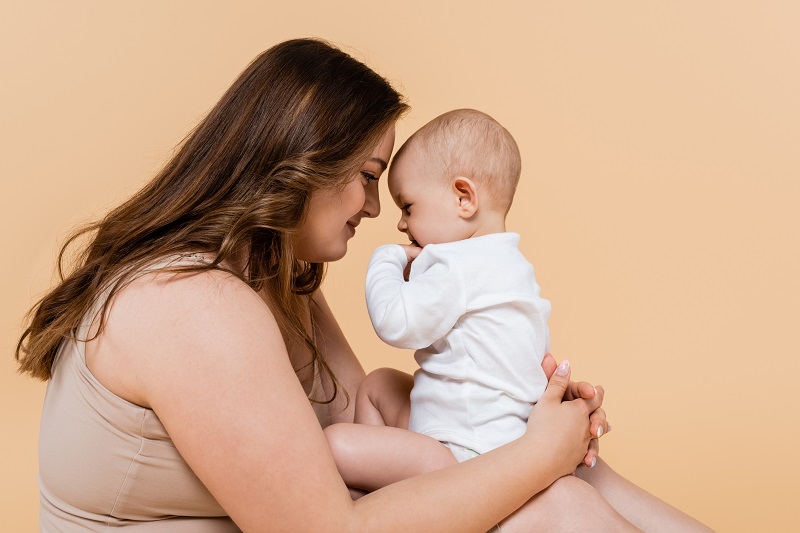 Side view of woman holding baby daughter