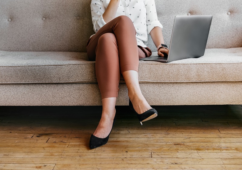 woman working on laptop with legs crossed