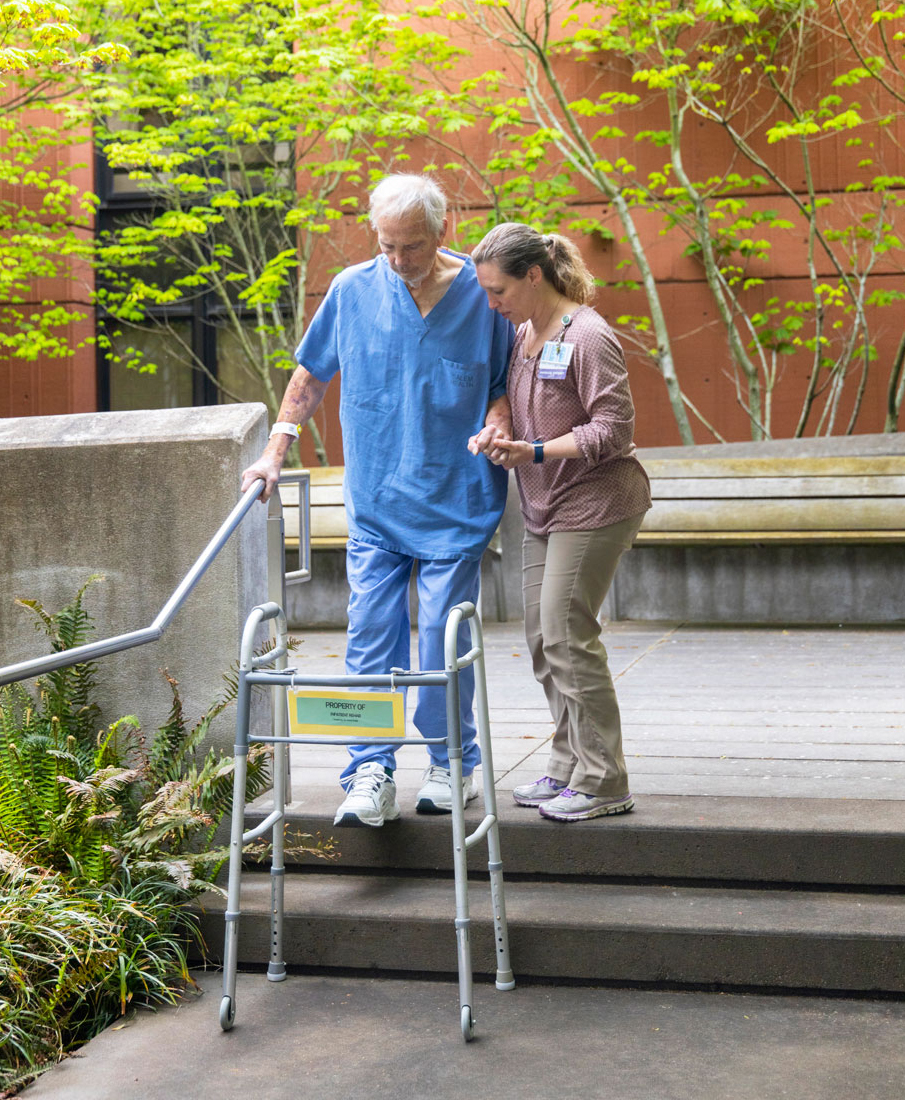 Patient and rehab specialist practicing in the Salem Health therapy courtyard.