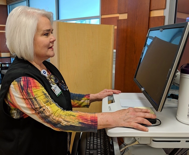 A volunteer uses a computer workstation in the Emergency Department waiting area.