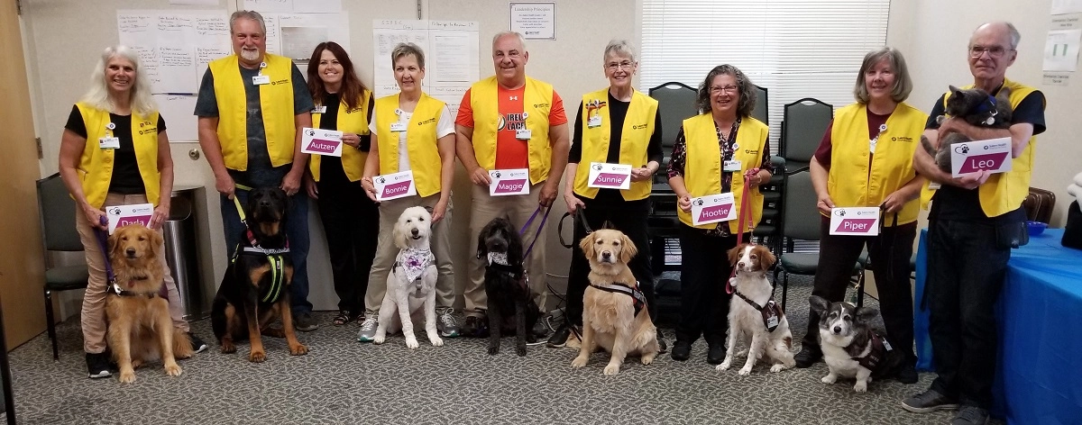 A group of volunteer pet therapy providers with their dogs and cats.
