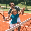 Middleageddadandyoungdaughterplaytennistogether