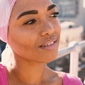Amiddle-agedbrown-skinnedwomanwearsaheadscarf