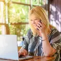 Anolderblondewomantalksonthephonewhiletypingonalaptop