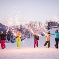 Familyandfriendsholidayskitripplayingwithsparklersoutdoorsinthesnow