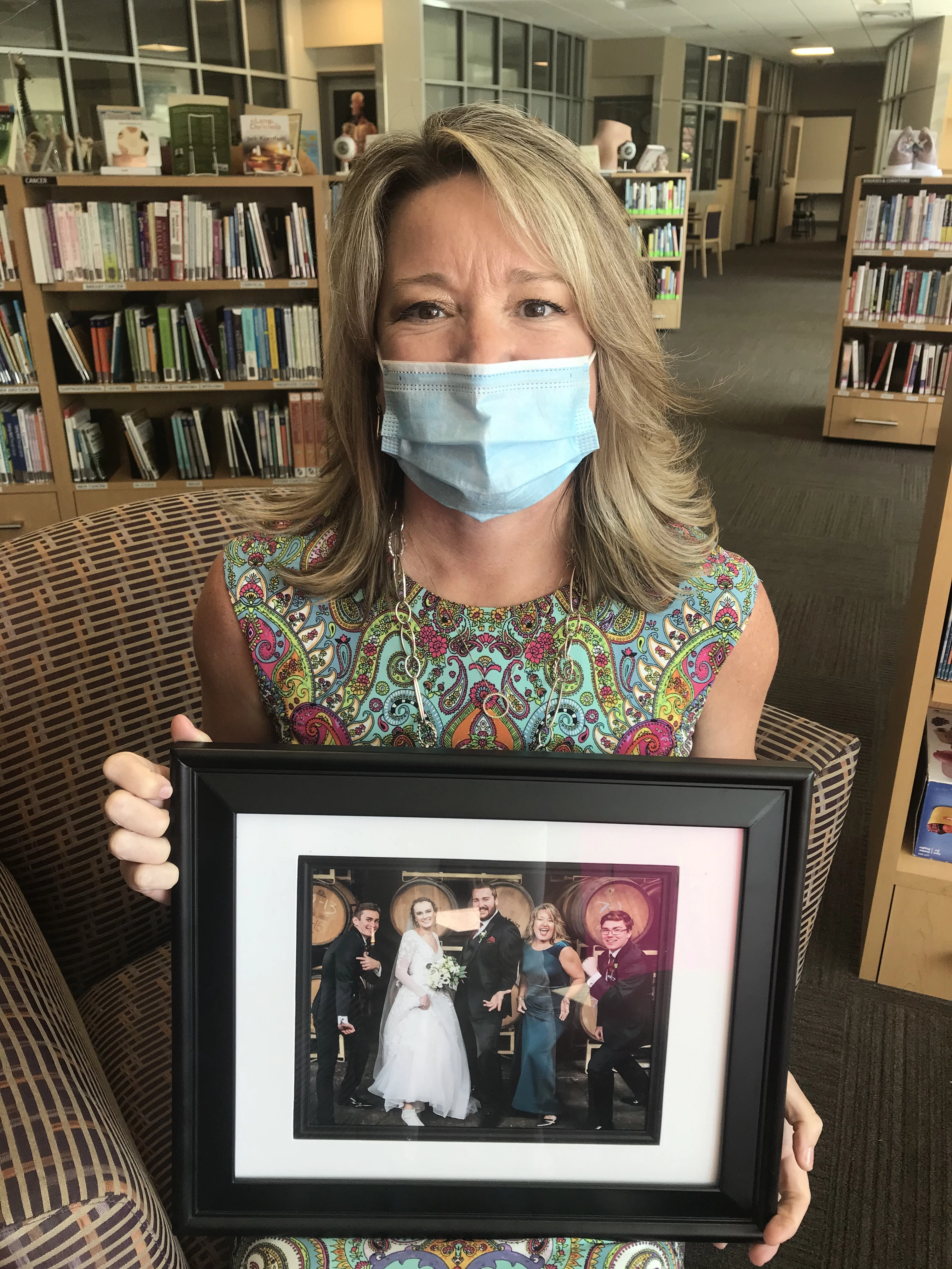 Cyndi L Holds a picture of a family wedding.