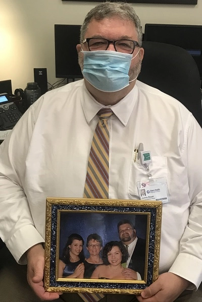 Jim B hold a photo of his family.