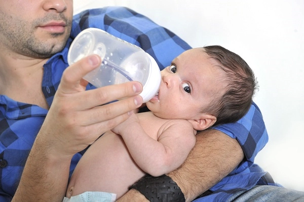 Dadfeedinganewbornwithabottle