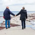 Anoldercouplewalkonthebeach