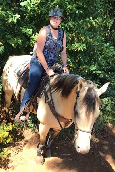 Meganridingabuckskinhorsethroughacreekonatrailride