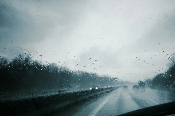 looking through a wet windshield at highway traffic