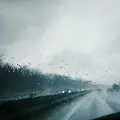 lookingthroughawetwindshieldathighwaytraffic