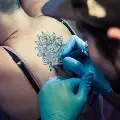 tattooartistworksonalargemandalaonacustomersback