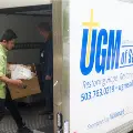WorkerscarryboxesofdonatedgoodsintotheUGMdonationboxtruck